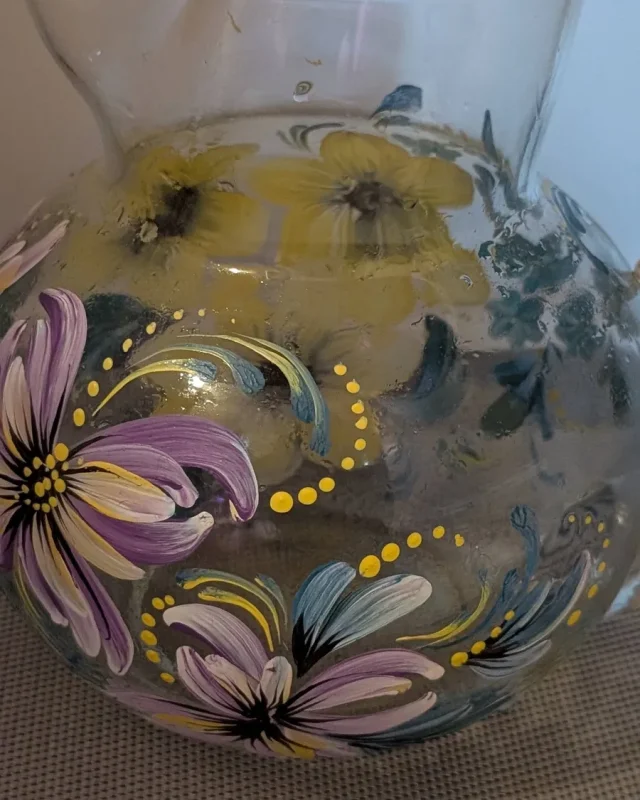 Decorative glass pitcher with purple and yellow florals