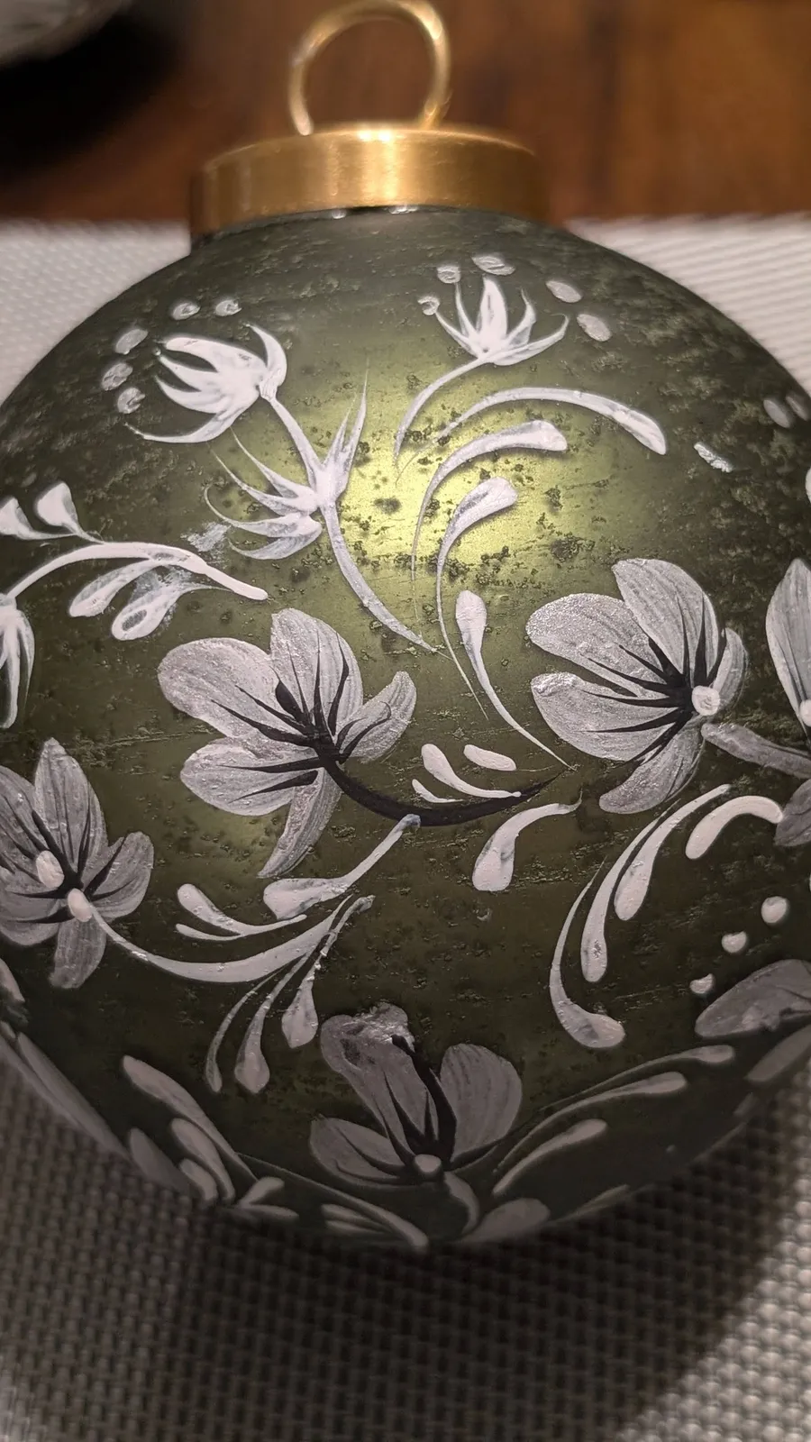Green and gold ornament with silver florals
