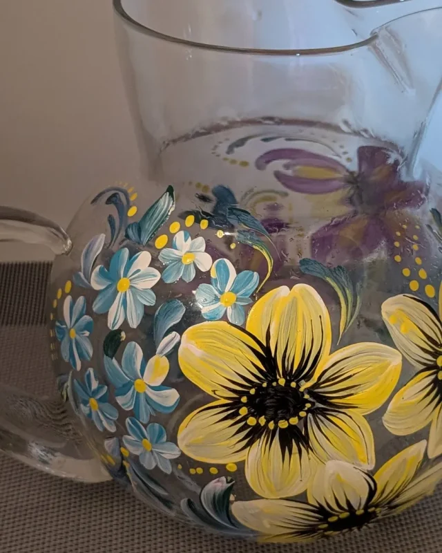 Glass pitcher with yellow sunflowers and blue accents